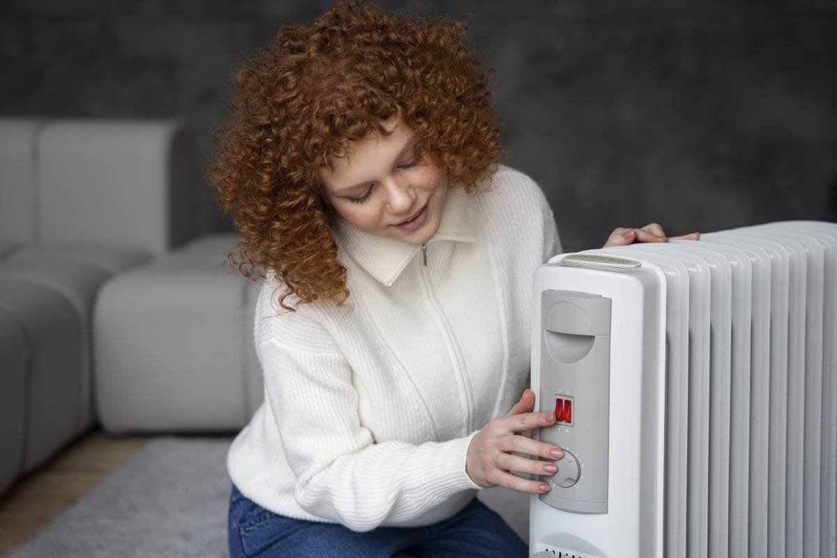 medium shot woman turning heater